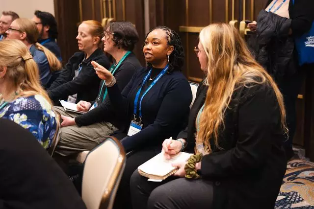 An attendee asks a question during a workshop session